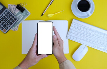 Poster - Hand using a smartphone, poster, businessman or manager holding a phone against a yellow background, internet marketing.