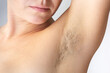 Woman hairy unshaved armpit with part of face on the white background