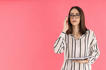 Young attractive woman in glasses on pink background