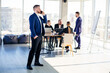 © DSMT - Business people, businessmen are working together in a modern office in a multi-storey skyscraper. The director is on the phone. Office work concept. Selective focus