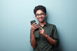 © AJay - Smiling young boy of Indian origin holding a mobile phone