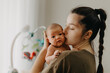 © Ananass - Beautiful woman holds a newborn baby in her arms