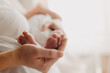 © Ananass - legs of a newborn baby in parental hands