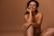 Self-confident beautiful Hispanic woman in beige underwear, smiles toothy smile looking at camera. Body positivity, self-acceptance and body love concept