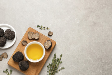 Wall Mural - Fresh truffles, oil in bowl and thyme on light grey table, flat lay. Space for text