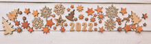 The Beautiful Christmas Background With A Lot Of Small Wooden Decorations And Wooden Numbers 2022 On The Dark Wooden Desk.