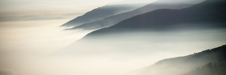 Wall Mural - Mountain view with foggy clouds in banner header picture. Silence and peaceful time in outdoors park nature landscape.
