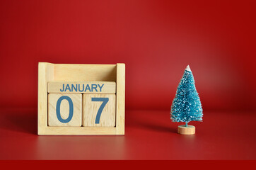 January 7, Calendar design with Christmas tree on red table background.