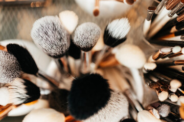 professional makeup brushes in tube. used makeup tools photographed from above. high angle view.