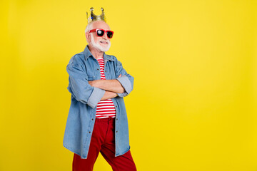 Sticker - Portrait of attractive cheery grey-haired man wearing crown folded arms copy space isolated over bright yellow color background