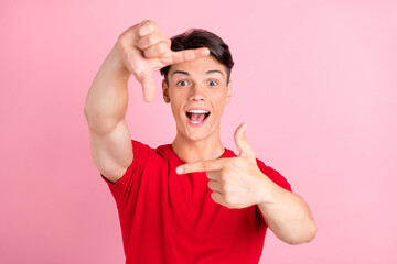 Poster - Photo of young guy happy positive smile show fingers frame border sign photographer isolated over pink color background