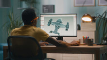 Black Man Using Computer And Creating 3D Model Of Futuristic Aircraft For Videogame Or Movie While Working From Home