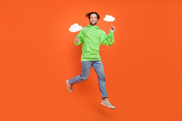 Wall Mural - Full size photo of brunet young guy jump hold bubbles wear sweater jeans shoes isolated on orange background