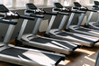 Side view of empty treadmills on wooden floor near panoramic window in fitness club.
