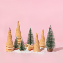 Christmas And New Year Creative Layout With Christmas Trees, Snow And Ice Cream Cones On Pastel Pink Background. Winter Creative Idea. 80s Or 90s Retro Aesthetic Food Minimal Concept.