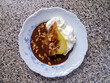 Top view of one poached caramelized pear with whipped cream, chocolate sauce and almond flakes. French dessert poire belle Helene.