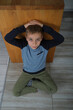 portret młodego chłopaka siedzącego na podłodze 