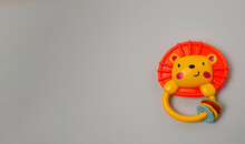 Plastic Toy In The Form Of A Lion Cub With A Handle On A Gray Background