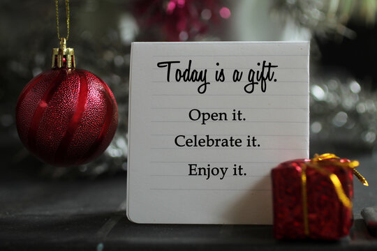 Wall Mural -  - Life inspirational quote on a notepaper - Today is a gift. Open it. Celebrate it. Enjoy it. With red Christmas ball ornament  and red gift box decoration on gray silver color background.