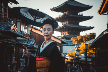 Wall Mural - Beautiful japanese senior woman walking in the village. Typical japanese traditional lifestyle