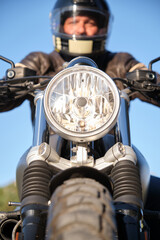 Motorcycle with spotlight on and rider out of focus.