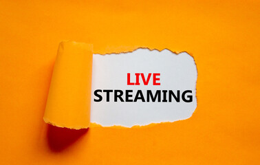 Live streaming symbol. Concept words Live streaming appearing behind torn orange paper. Beautiful orange background. Business, live streaming concept, copy space.