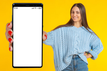 Poster - Big phone. Smartphone in woman's hand. Beautiful girl is holding cellphone. Mockup for website or application. Mobile phone for applications. Smartphone mock up. Hand with big phone on yellow