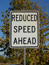 Reduced Speed Ahead Sign On Side Of Road