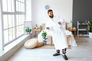 Canvas Print - Dancing young man wearing bathrobe in bedroom