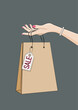 Dłoń trzymająca papierową torbę na zakupy z zawieszką 