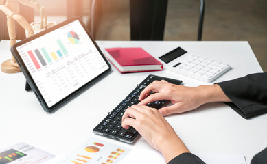 Wall Mural - woman hands using portable tablet analyzing business graph chart.