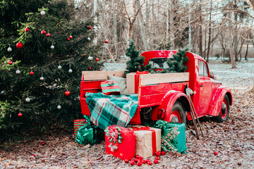 red car pickup truck decorated with Christmas wreath, blankets, pillows and gift boxes with presents is standing in forest, Santa Claus's magic transport, New Year and Christmas banner background