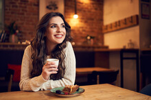 Portrait Of Woman Sitting In Cafe Having Coffee And Cake