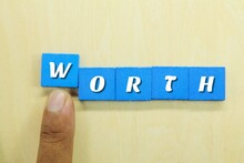 The Hand Pushes The Blue Square With The Word Worth
