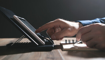 Wall Mural - Man working at tablet and writes in notepad.