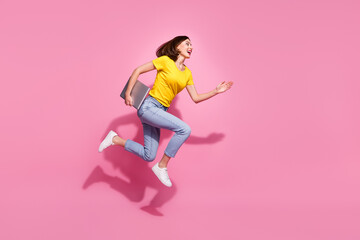 Poster - Photo of cute pretty young lady dressed yellow clothes smiling hurrying jumping carrying modern gadget isolated pink color background