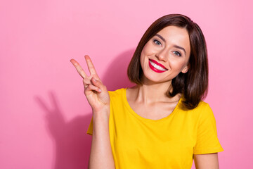 Sticker - Photo of shiny pretty young lady dressed yellow clothes smiling showing v-sign isolated pink color background