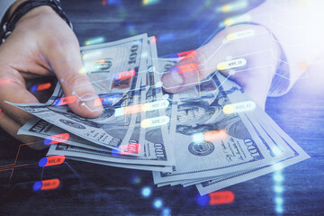 Multi exposure of technology drawing hologram and us dollars bills and man hands. Data concept