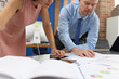 © H_Ko - Business man and woman studying documents at table in office closeup