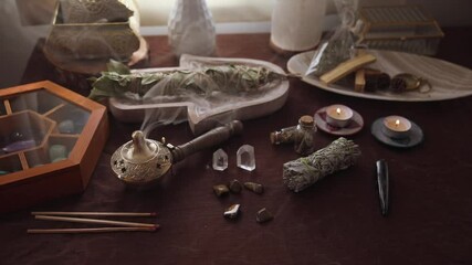 Wall Mural - Altar for energetic cleansing and witch rituals with various bundles, stones and crystals and a medicinal herb burner with smoke coming out