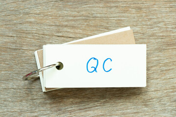 Sticker - Flash card with handwriting word QC (Abbreviation of Quality Control) on wood background