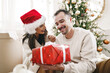 © fotofabrika - Young cheerful couple in love with present for Christmas
