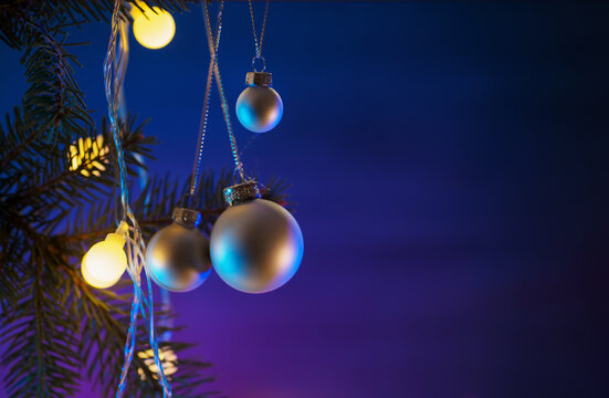 Merry Christmas background for copyspace. balloons hanging on the branches of the Christmas tree , round yellow garland, blue wooden background