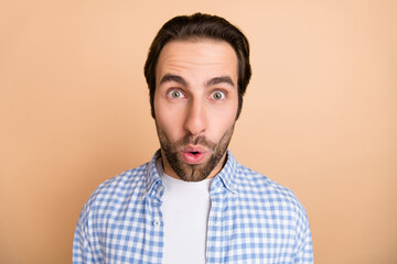 Poster - Photo of impressed young guy look camera wear plaid shirt isolated on beige color background