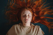Young freckled redhead woman lying down eyes closed - flat lay concept portrait