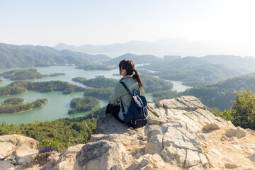 Canvas Print - Woman sit on the top of mountain and look at the view