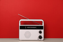 Retro Radio Receiver On Table Against Red Background