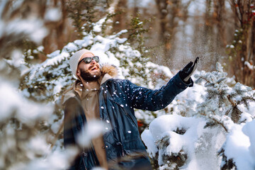 Wall Mural - Portrait of  young man  in snowy winter forest. Season, christmas, travel and people concept.