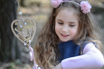 Picture of an ethnic styled little girl with long hair in a headband playing in the forest