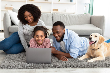 Poster - Black family using pc relaxing with dog at home